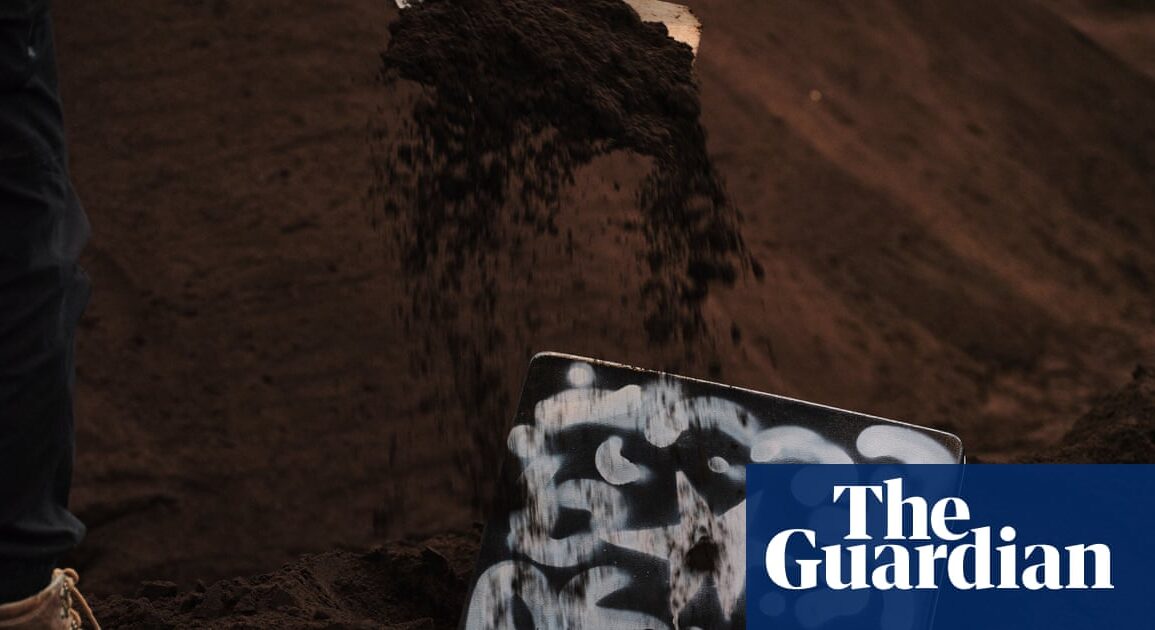 Sydney'deki Carriageworks'te 'Heap' enstalasyonunda toprağa gömülü sanat eserlerinin kazı anı.
