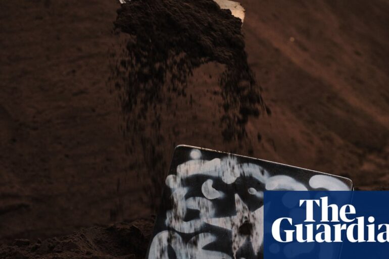 Sydney'deki Carriageworks'te 'Heap' enstalasyonunda toprağa gömülü sanat eserlerinin kazı anı.